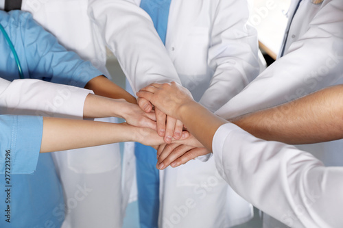 Team of medical workers holding hands together, closeup. Unity concept © New Africa