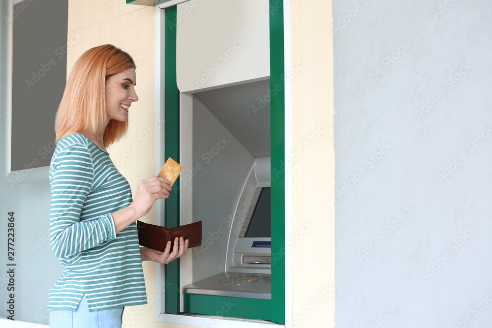 Beautiful woman with credit card near cash machine outdoors, space for text Beautiful woman with credit card near cash machine outdoors, space for text