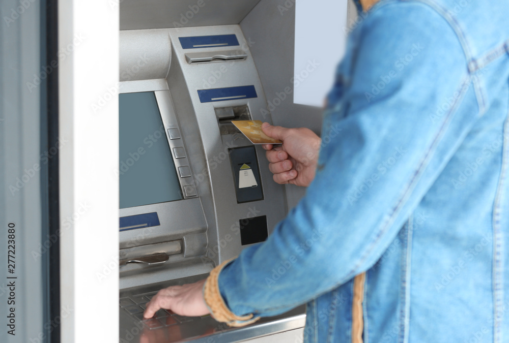 Man using cash machine for money withdrawal outdoors, closeup Man using cash machine for money withdrawal outdoors, closeup