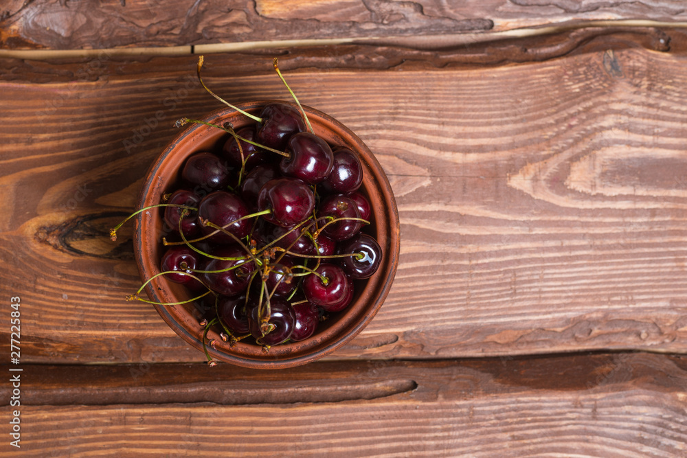 Fresh sweet sweet cherry in a plate on a wooden background. Fresh sweet sweet cherry in a plate on a wooden background.
