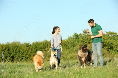 Young couple walking their dogs in park
