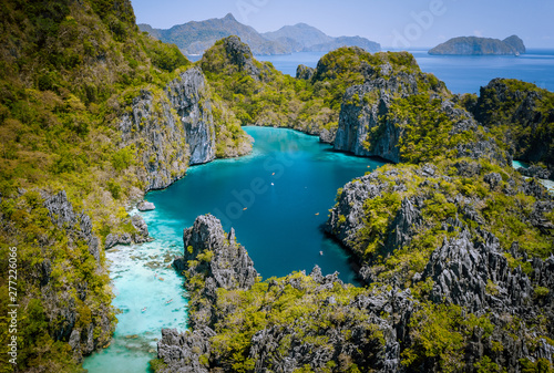 El Nido  Palawan  Philippines. Aerial drone view of beautiful big lagoon surrounded by karst limestone cliffs. Tourists explore area on kayaks