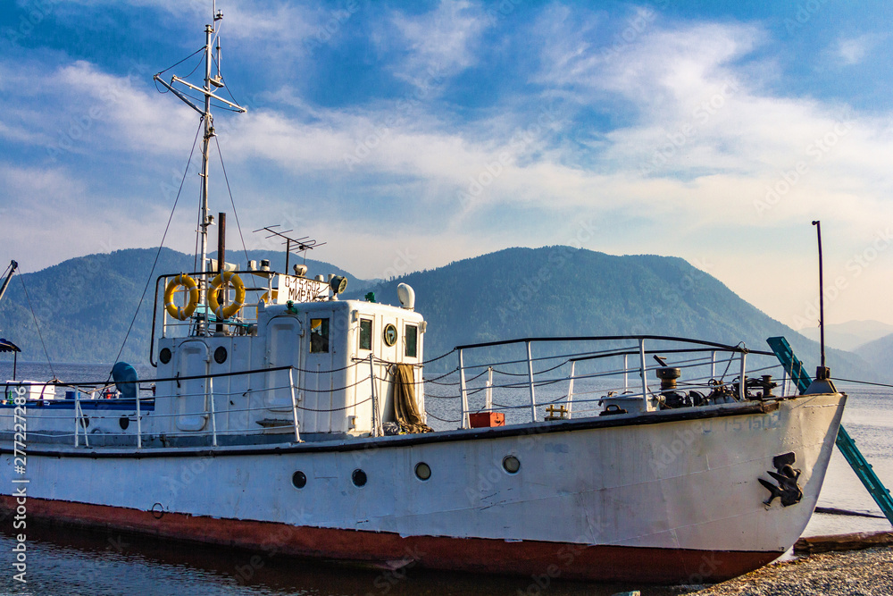Naklejka premium old ship moored on seashore at sunny day 