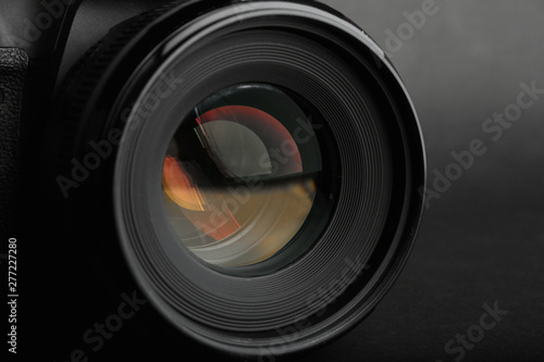 Modern camera with lens on black background, closeup