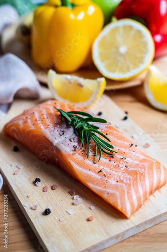 Fresh salmon steak with herbs, lemon and ingredients for cooking in kitchen