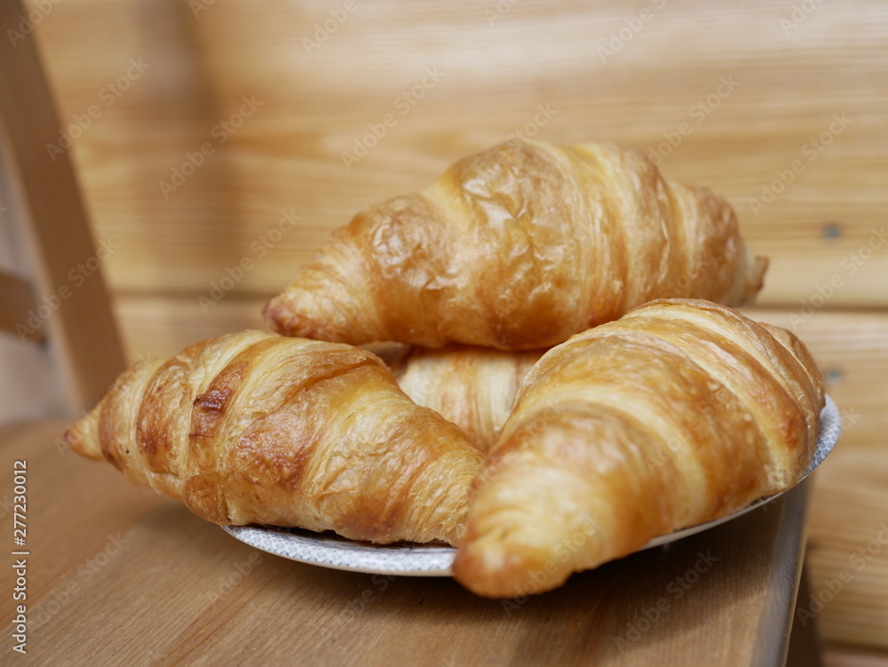 Freshly baked croissants on a small white plate