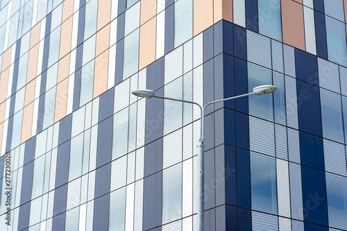 A pillar with street lamps against the backdrop of a modern building. Concept - view of the sleeping area of a big city with cozy courtyards.