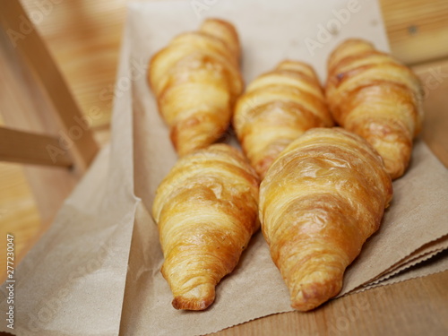 five fresh croissants lying on a package from the bakery. delicious pastries © Vladimir Kazachkov