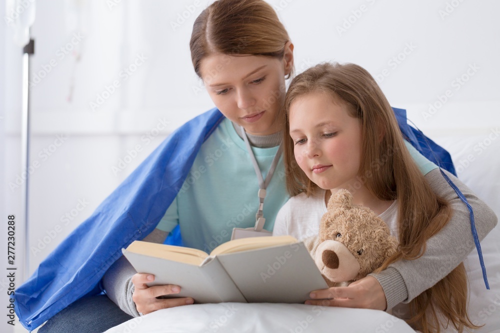 Φωτογραφία Young blond girl and a volunteer reading her