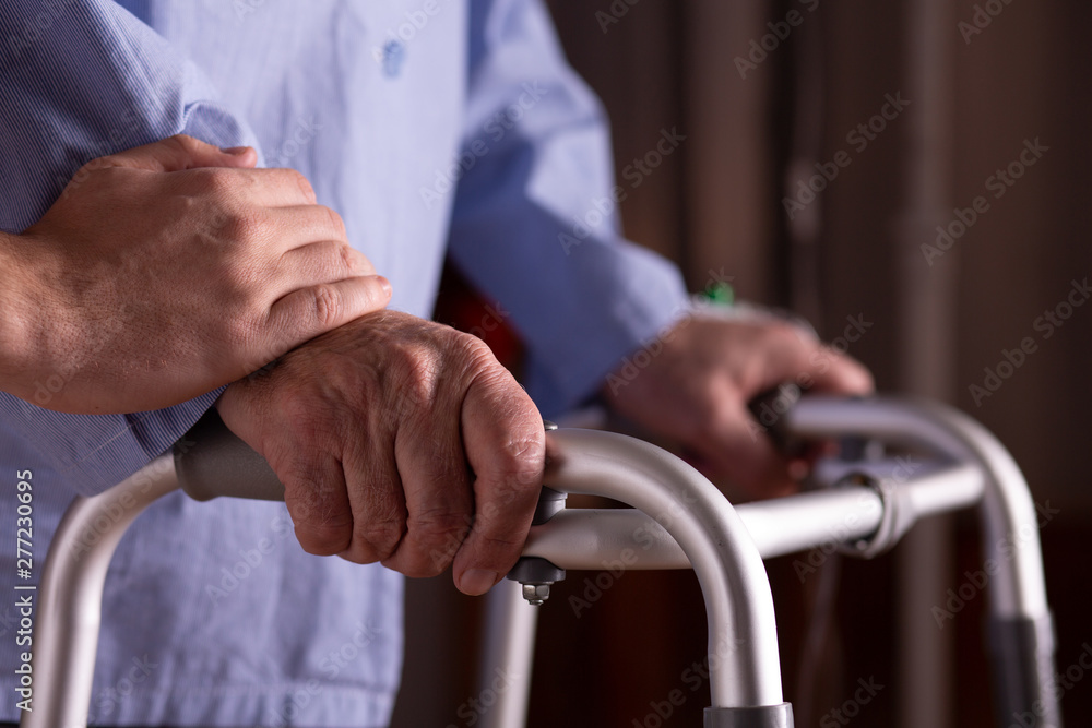 Closeup of senior man's hands holding walker at nursing home