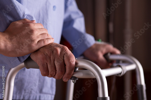 Closeup of senior man s hands holding walker at nursing home