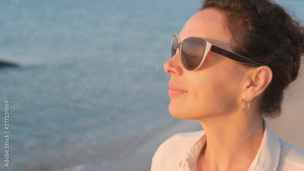 Reflection of a solar track in sunglasses. Pretty woman in sunglasses enjoys the sunrise on the seashore. Reflection of a solar track in sunglasses. Pretty woman in sunglasses enjoys the sunrise on the seashore.