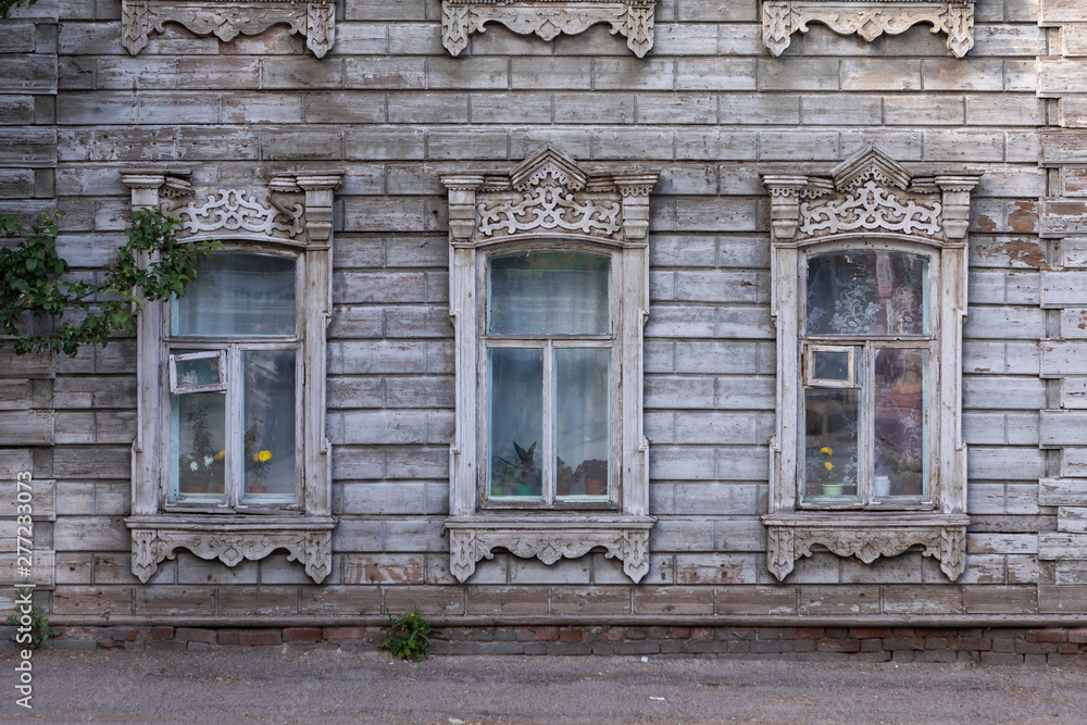 Old house with wooden shutters in Russia. Facade of a vintage house with blue gray walls