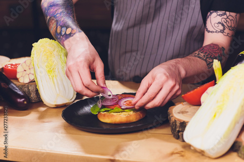 Chef making healthy vegetarian salmon burgers outdoor on open kitchen, odprta kuhna, international food festival event. Street food ready to be served on a food stall. photo