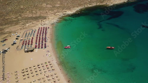 Aerial drone video of famous organised with sun beds and umbrellas beach of Lia with emerald clear sandy sea shore, Mykonos island, Cyclades, Greece   photo