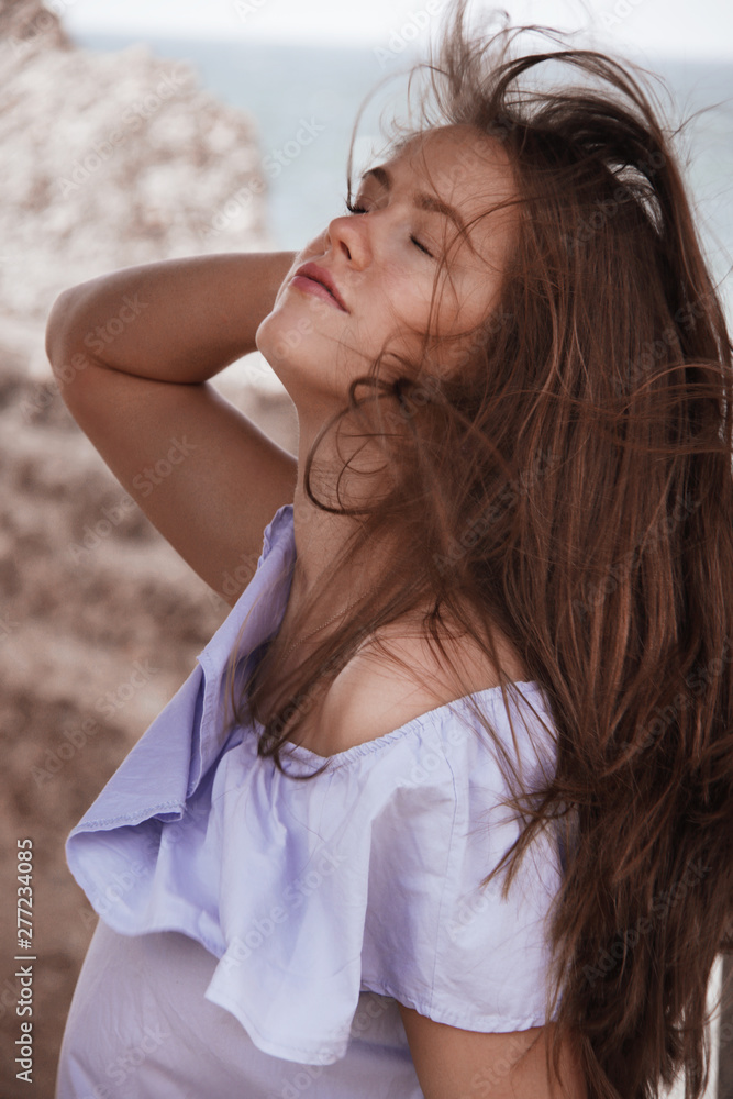 Naklejka premium caucasian woman in blue dress on the beach
