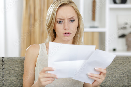 woman reading a letter with a concerned expression