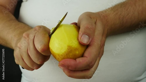 Hands removing skin yellow potato
