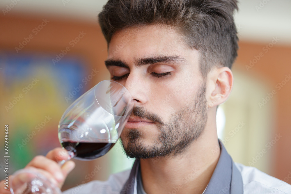 portrait of happy man tasting wine in winery portrait of happy man tasting wine in winery