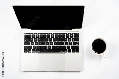 White office work space desk table with laptop and cup of black coffee. Top view with copy space, flat lay.