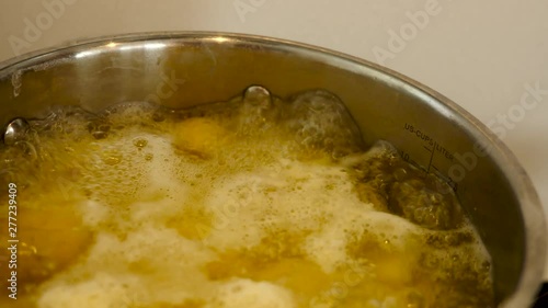 brown potato in boining water