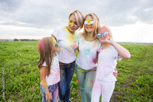 Family, festival of holi and holidays concept - portrait of happy family covered in paint