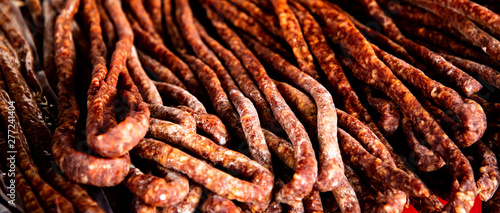 Dry meat salami or sausage on wicker basket