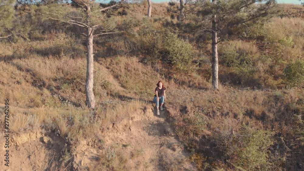 Aerial video of woman sits on the edge of a cliff. Flying over a cliff near the sea or ocean in Odessa Aerial video of woman sits on the edge of a cliff. Flying over a cliff near the sea or ocean in Odessa