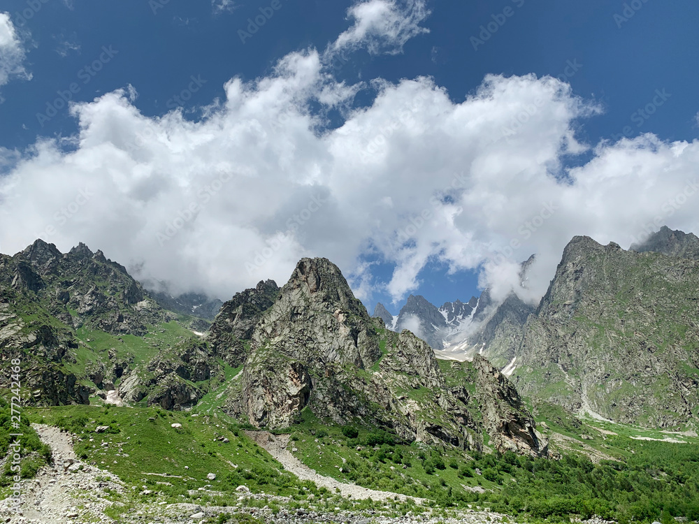Russia, North Ossetia - Alania. The tops of the mountains framing Tsey (Tseyskoe, Tseyskoye) gorge in sunny June day