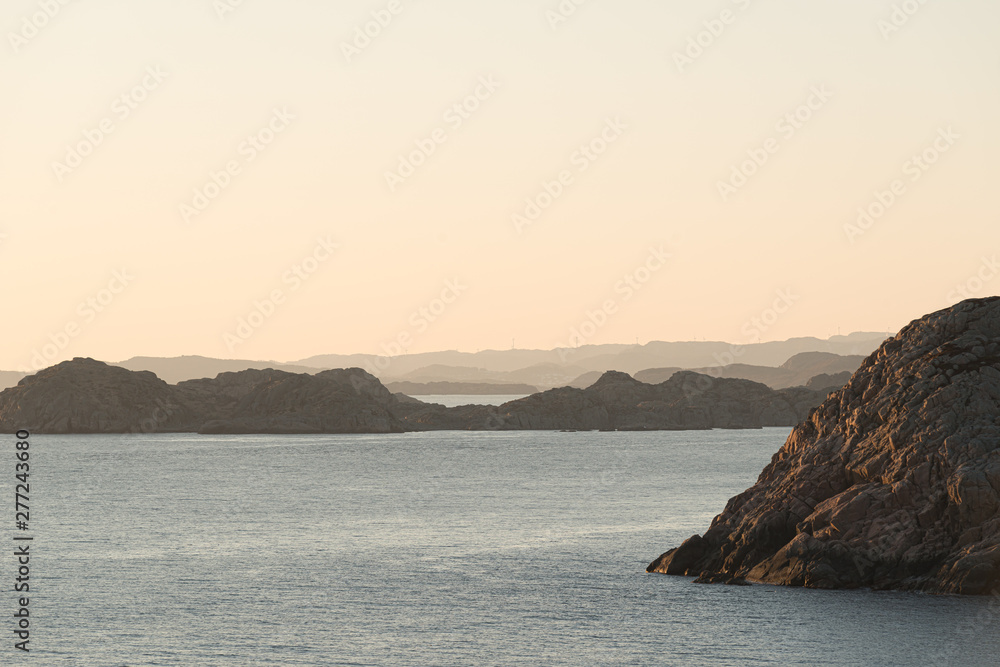 View of steep cliffs by the sea at sunset.