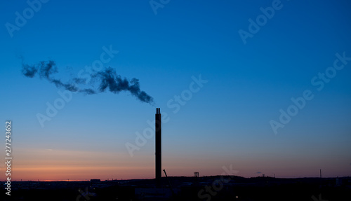 Smoke from a power plant chimney at sunset.