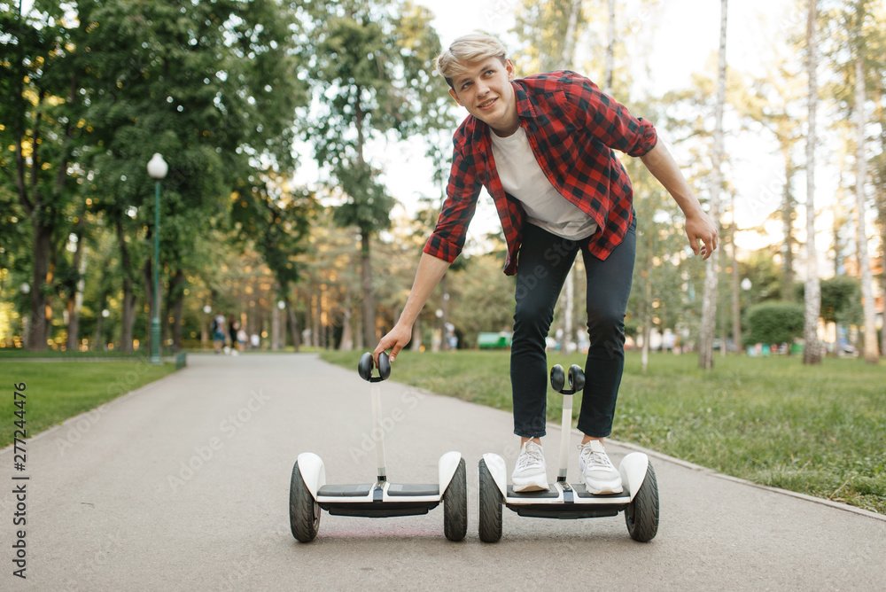 Young man riding on gyro board in summer park Young man riding on gyro board in summer park