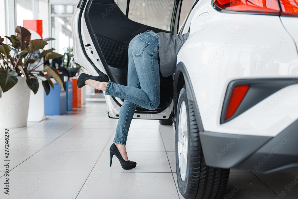 Woman's ass sticking out of new car in showroom Woman's ass sticking out of new car in showroom