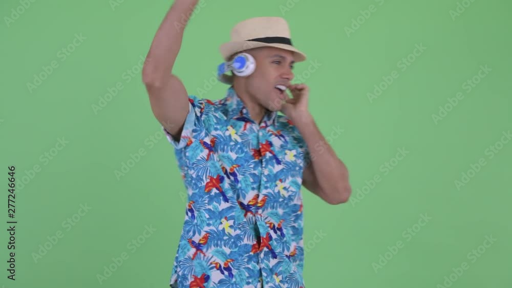 Happy multi ethnic tourist man dancing with headphones Happy multi ethnic tourist man dancing with headphones