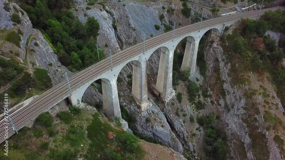 Aerial, tilt down, drone shot, towards a old railway bridge, in the Swiss alps, on a cloudy day, near Leuk, in Vallis, Switzerland Aerial, tilt down, drone shot, towards a old railway bridge, in the Swiss alps, on a cloudy day, near Leuk, in Vallis, Switzerland