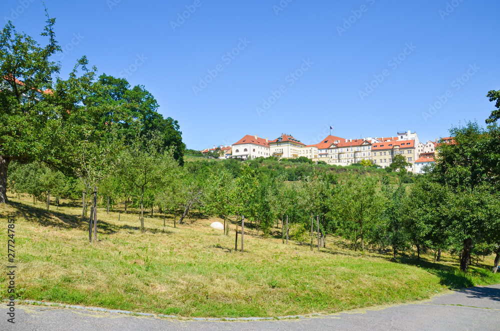 Beautiful green gardens on Petrin Hill in Prague, Czech Republic. Historical buildings in background. Taken on sunny day, blue sky. Popular tourist spot offering view over beautiful city. Czechia
