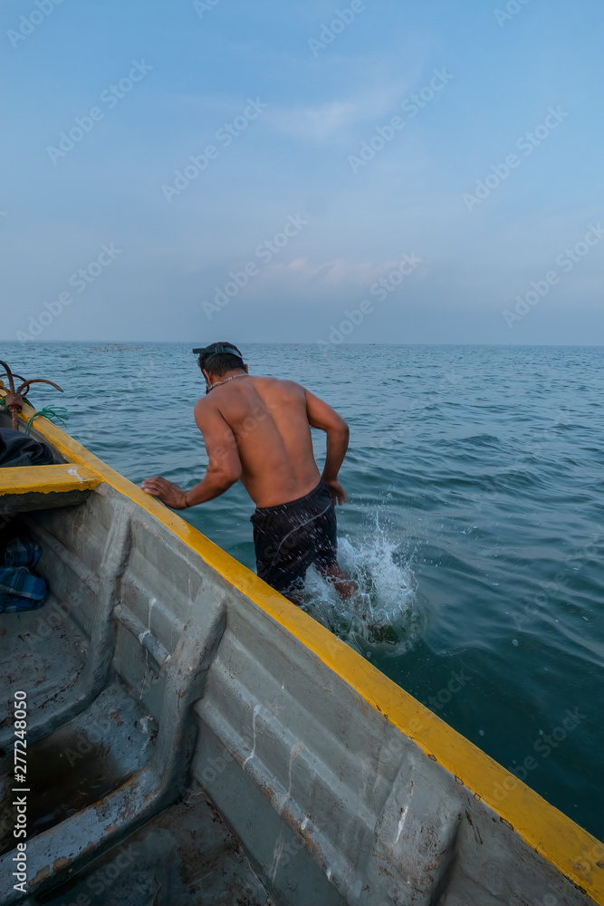 Obraz premium A Fisherman Jumping into the Water to Check His Nets, Jaffna, Sri Lanka