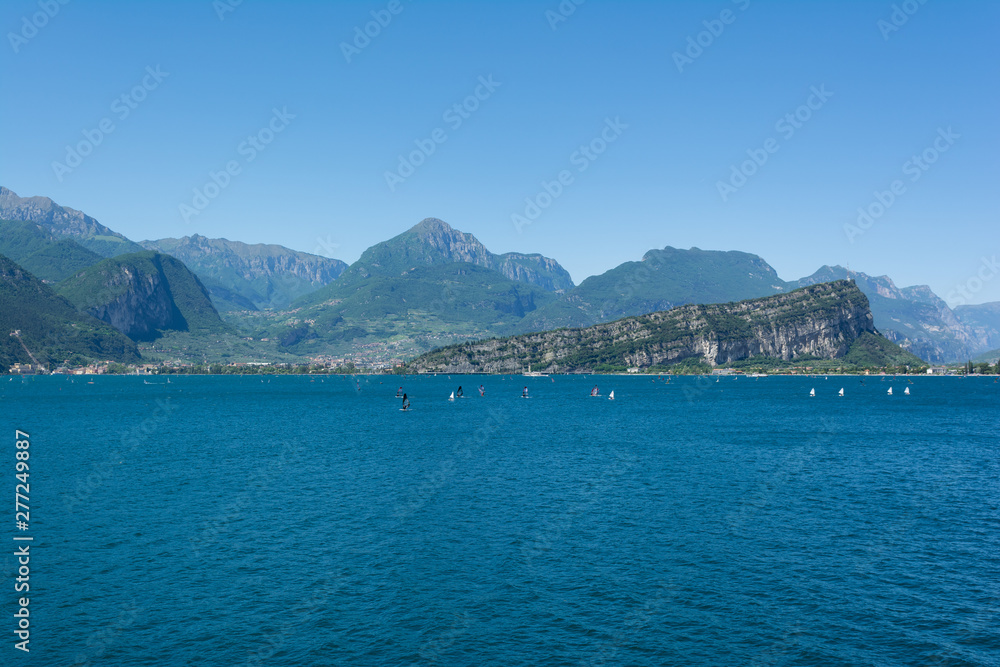 Beautiful view of Riva Del Garda and Nago-Torbole coastline and beaches with lots of windsurfers and boats, Italy