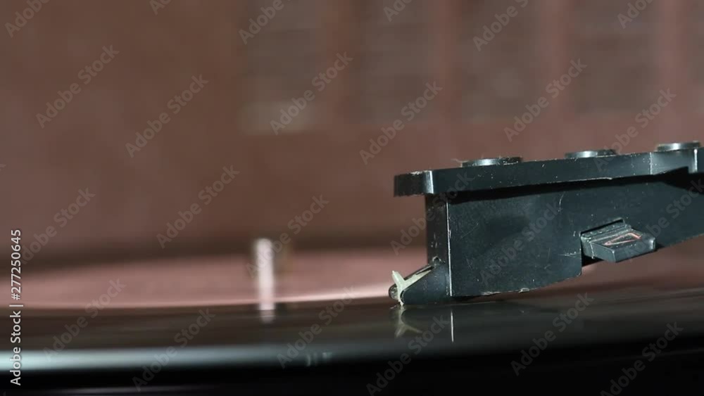 Vinyl record spins on the player. Visible pickup needle. Everything is covered with dust. Vinyl record spins on the player. Visible pickup needle. Everything is covered with dust.
