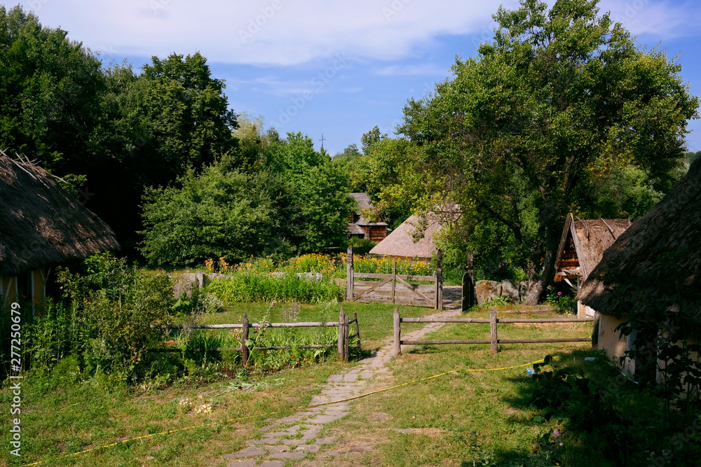 Old Ukrainian house. Ukrainian hut of the nineteenth century. Summer landscape, flowers in front of the house, sunlight. Village Pirogovo. Old Ukrainian house. Ukrainian hut of the nineteenth century. Summer landscape, flowers in front of the house, sunlight. Village Pirogovo.