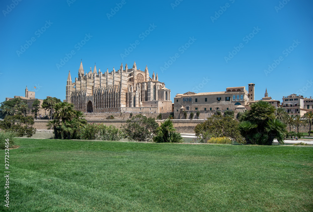 Majorca 2019: Cathedral La Seu of Palma de Mallorca on a sunny summer day with blue sky. Image composition with grass in the foreground