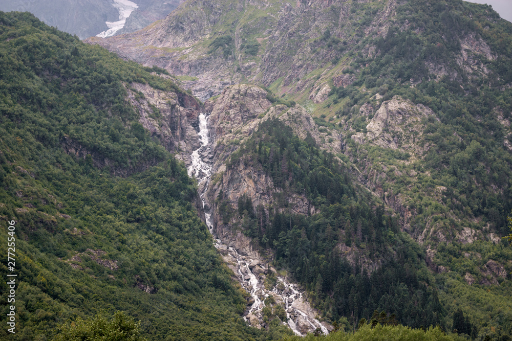 Panorama view on mountains scene and away waterfall in national park of Dombay