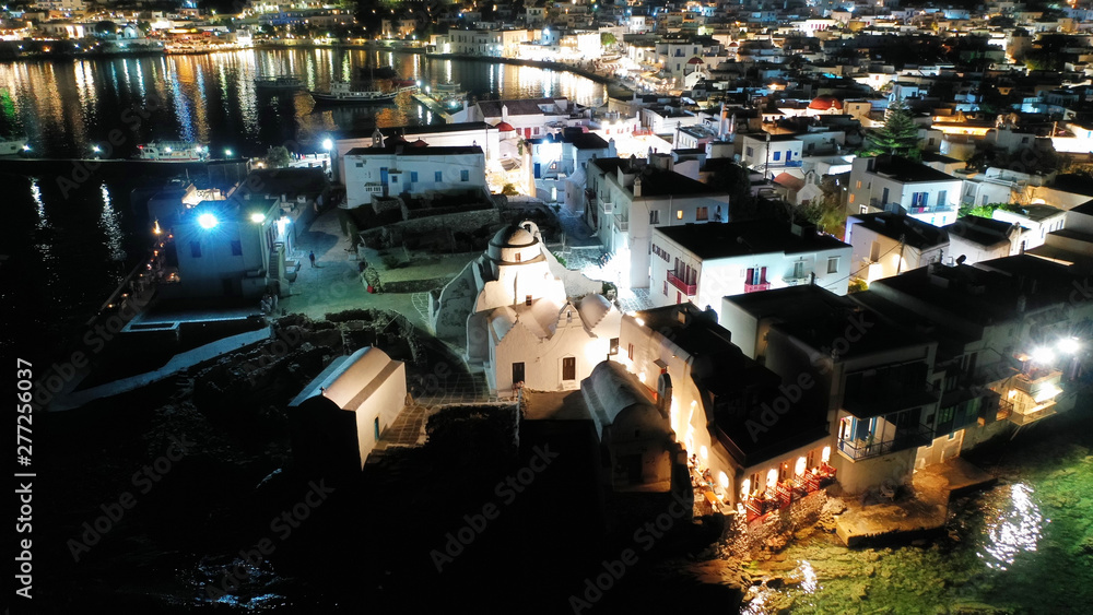 Obraz premium Aerial drone night shot of iconic and picturesque illuminated Little Venice in main town of Mykonos island nect to famous chapel of Paraportiani, Cyclades, Greece