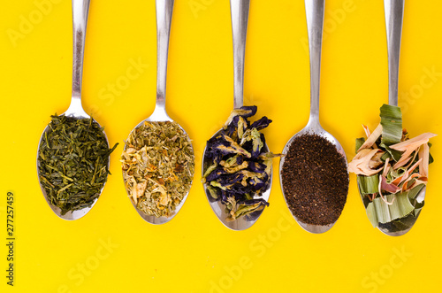 Leaves of different varieties of tea in spoons
