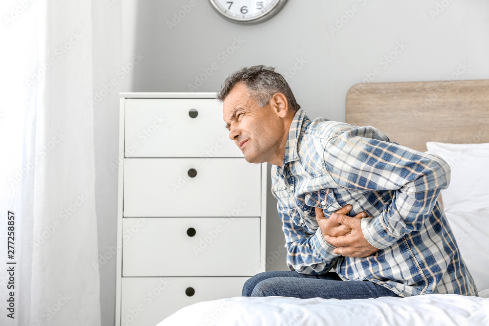 Fototapeta premium Mature man suffering from heart attack at home