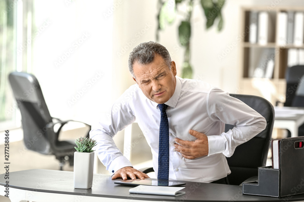 Mature man suffering from heart attack in office Mature man suffering from heart attack in office