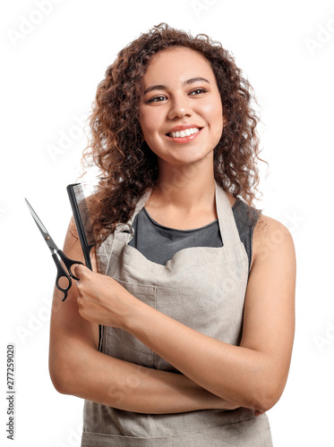 Beautiful African-American hairdresser on white background