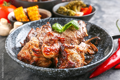 Plate with tasty grilled meat on table