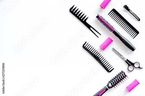 Combs, sciccors and pink hairdresser tools in beauty salon work desk on white background top view space for text