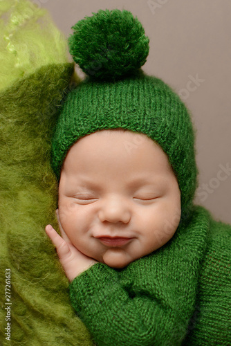Sleeping newborn boy on a brown  background. 